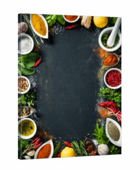 Herbs and spices over black stone background