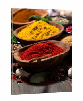 assortment of spices and herbs on a wooden table, closeup