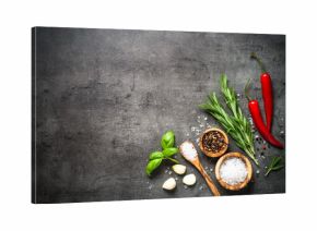 Selection of spices herbs and greens on black top view. 