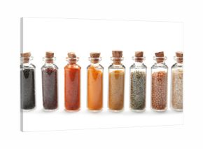 Row of small glass bottles with different spices on white background