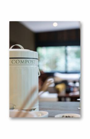 Compost bin on kitchen counter with olive oil bottles in modern home