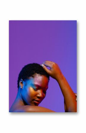 African american woman with short hair and colourful make up touching head, eyes closed, copy space