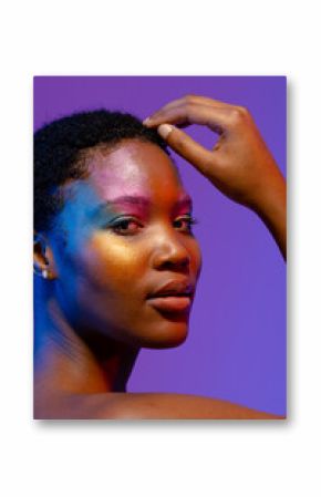 African american woman with short hair and colourful make up touching head