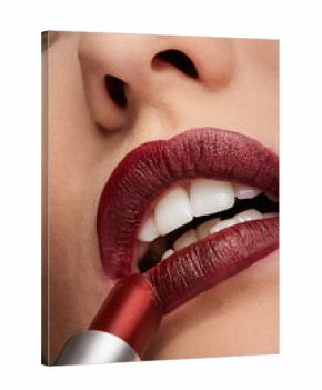 Woman applying red lipstick on mouth