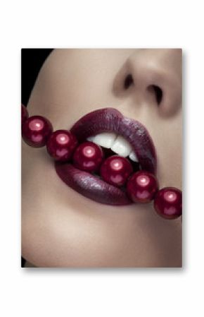 Woman bitting with red lips red pearls