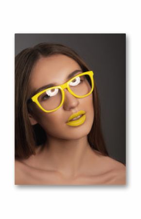 close-up portrait of a beautiful young brunette woman with yellow lips in yellow sunglasses 