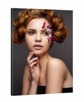 Beautiful girl with creative make-up with floral appliques. The model in the style of romantic with flower petals around her eyes. The photo was made in a studio. Beauty face