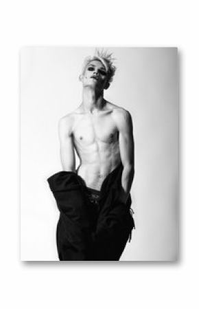 Freaky gothic fashion model boy with blonde hair, piercing and black make up in black mantle