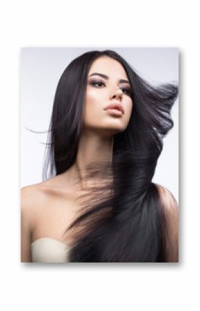 Beautiful brunette girl in move with a perfectly smooth hair, and classic make-up. Beauty face. Picture taken in the studio on a white background.