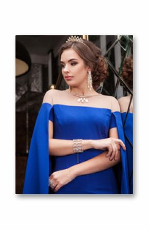 portrait of a beautiful young girl in a blue dress on a backgrou
