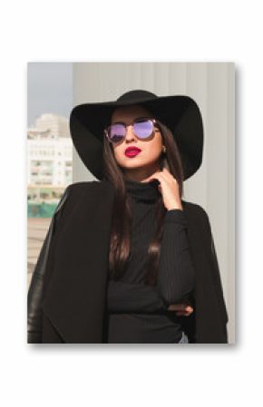 Lifestyle portrait of beautiful model in trendy black coat and black hat.Female fashion concept