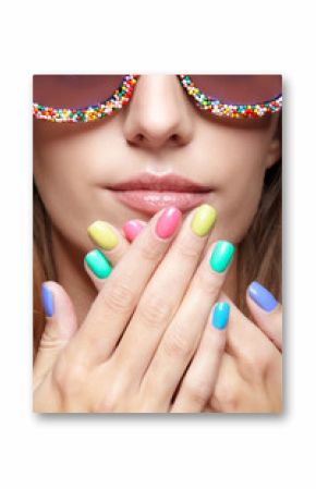 Young blonde woman with fun candy glasses and varicoloured finger nails manicure
