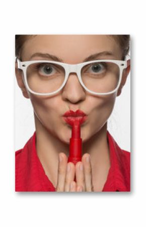 Beautiful young brunette girl in glasses with red lipstick on lips and in hands in shirt