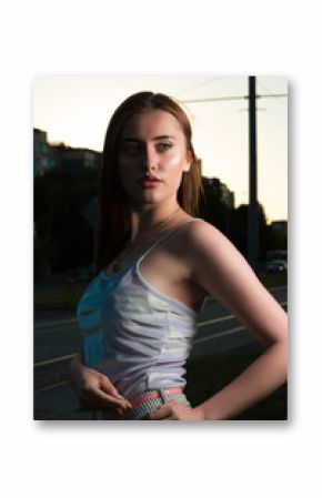 Adorable young brunette woman posing in the shadows at the street
