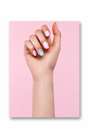 Beautiful pink and blue manicure with crystals on female hand. Close-up. Picture taken in the studio