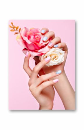 Beautiful pink and blue manicure with crystals on female hand. Close-up. Picture taken in the studio