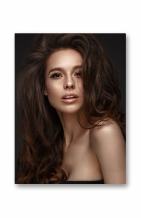 Beautiful brunette model with volume curls, classic makeup and sexy lips. The beauty of the face. Portrait shot in the studio.