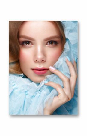 Beautiful girl with light make-up and gentle manicure in blue clothes. Beauty face. Design nails. Photo taken in studio on pink background