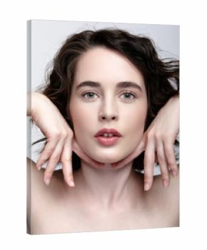 Closeup beauty portrait of young woman with hands near face
