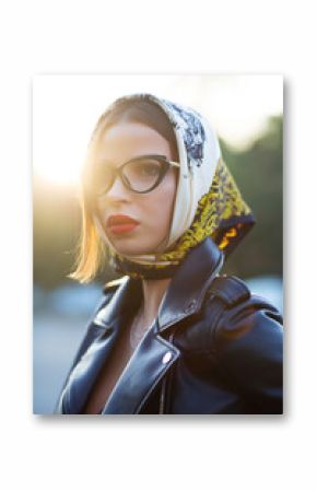Street shot of fashionable brunette model with red lips wearing shawl and glasses