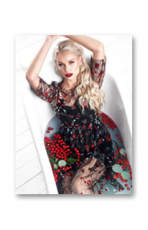Beautiful girl in a summer dress in the bathroom with flowers. Beauty face. Photo taken in the studio