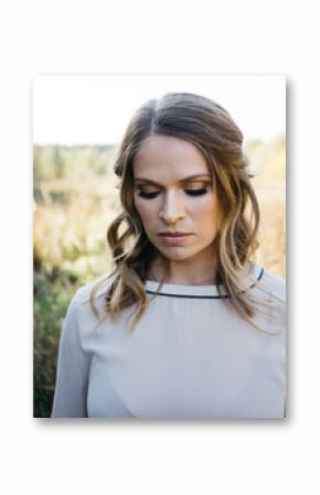 Beautiful woman with makeup and hairstyle in summer field