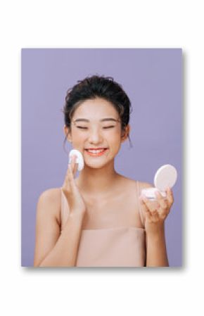 Beautiful asian woman applying blusher on her face with powder