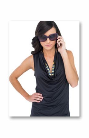 Serious elegant brunette wearing sunglasses on the phone