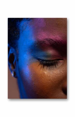 Close up of african american woman with short hair and colourful make up with eye closed