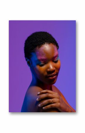 African american woman with short hair and colourful make up looking down with hand on shoulder