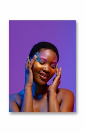 Smiling african american woman with short hair and colourful make up touching temples, copy space