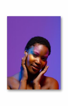 African american woman with short hair and colourful make up touching face, copy space