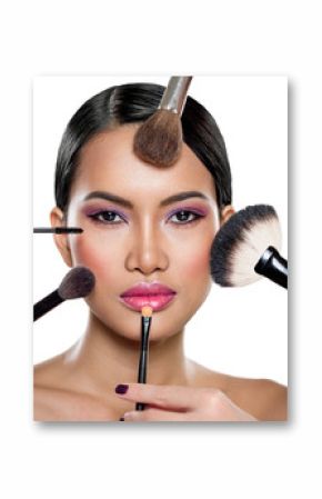 many hands applying make up on a woman