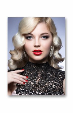 Beautiful blonde in a Hollywood manner with curls, red lips and lace dress. Beauty face. Picture taken in the studio on a white background.