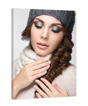 Beautiful girl with gentle makeup, design manicure and gray hat. Warm winter image. Beauty face