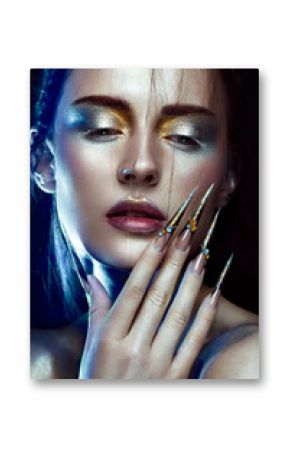 Beautiful girl with creative golden and silver glitter make-up and long nails art. The beauty of the face. Photos shot in studio