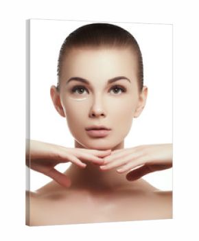 portrait of beautiful woman applying some cream to her face for skin care