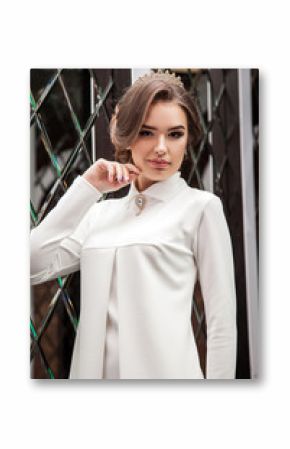 portrait of a beautiful young girl in a white dress on a backgro