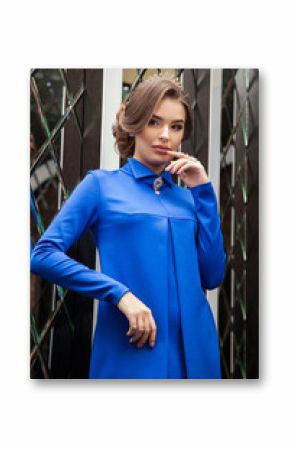 portrait of a beautiful young girl in a blue dress on a backgrou