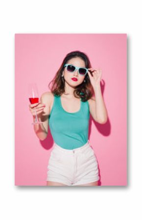 Celebrating asian girl with professional makeup and stylish hairstyle holding a glass of champagne.