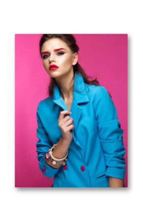 Beautiful girl in blue suit on pink background with creative make-up and fashionable style. Beauty face. Photo taken in the studio.