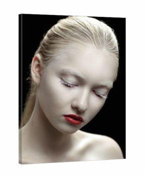 Pretty sensual woman in cosmetics looking down on a dark background.