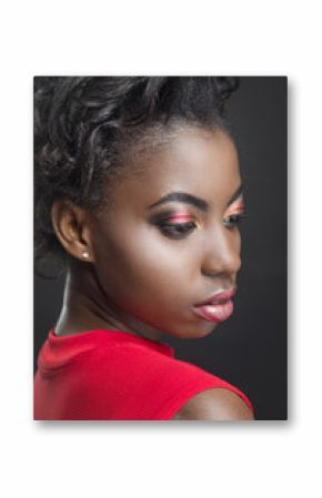 African woman with bright makeup looking down