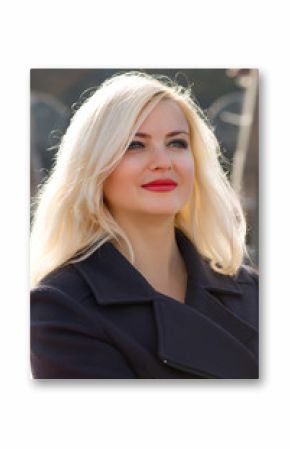 Amazing blonde woman with bright makeup posing in black coat at the city
