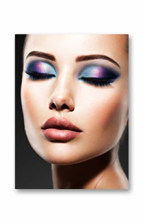 Beautiful face of an young woman with blue makeup of eyes