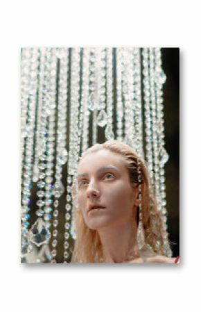 portrait of beautiful blonde attractive stylish young woman in luxury interior standing near the chandelier