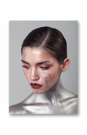 Beauty portrait of woman with silver body and tatoos