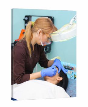 Young beautiful woman making permanent makeup in cosmetology salon.