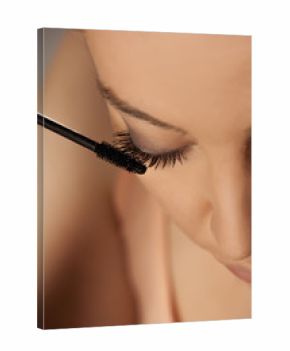 Closeup of young woman applying mascara