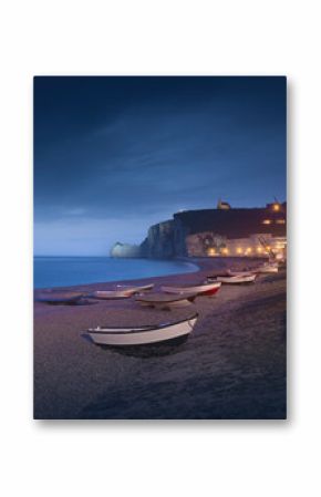 Blue hour over the boats and beach of Etretat on a foggy evening. Normandy, France.